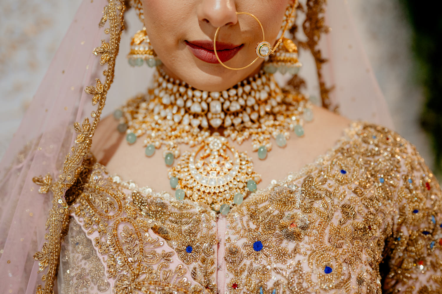 A closeup detail photo of an Indian bride adorned in jewels and accessories