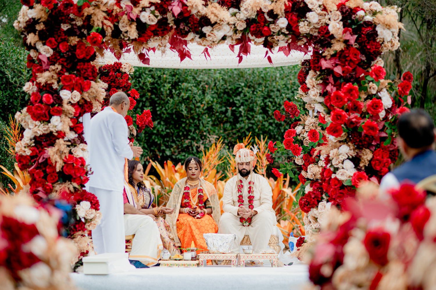 A traditional Hindu wedding ceremony held under a mandap covered in roses